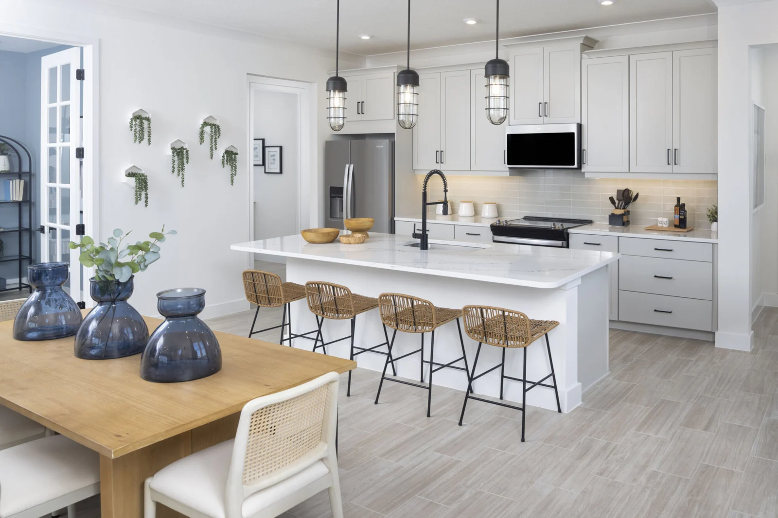 Single-Wall Kitchen with pendant light, refrigerator, white cabinets, painting, door, range and wood flooring